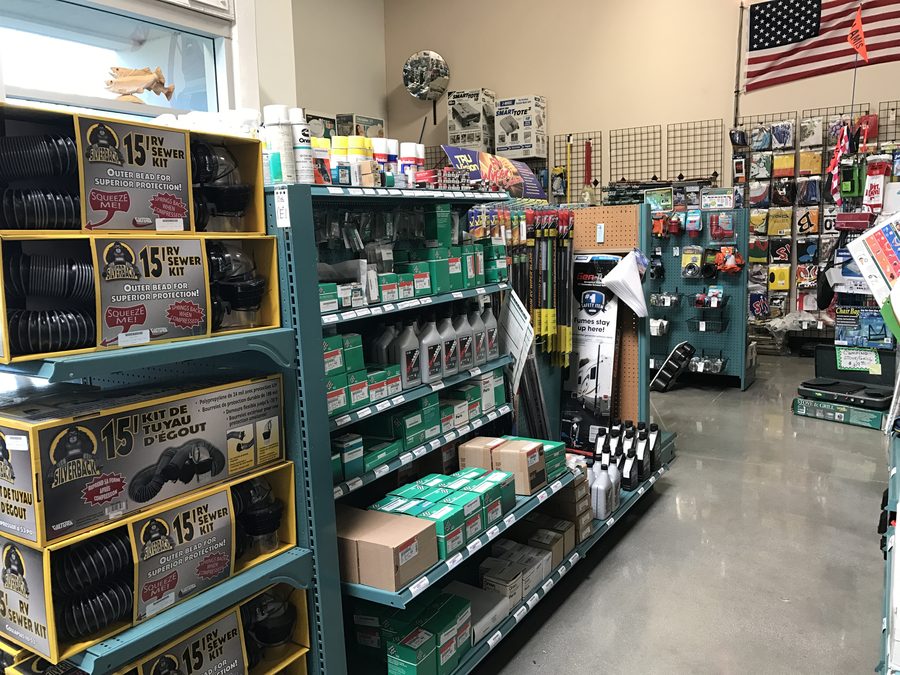 Inland Valley RV supply store shelving stocked with sewer kits, oil, and RV parts